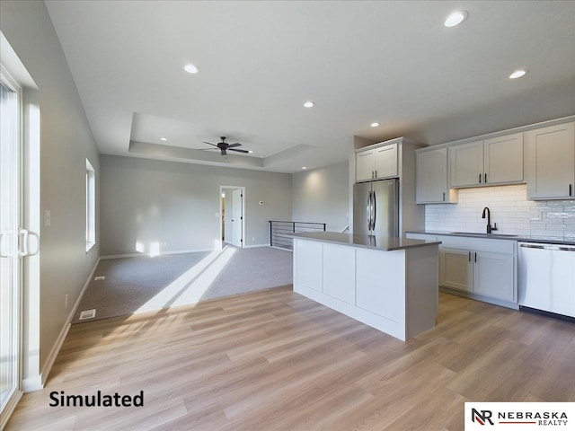 kitchen with sink, ceiling fan, tasteful backsplash, light hardwood / wood-style floors, and stainless steel appliances