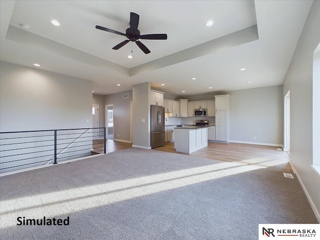 kitchen featuring a center island, white cabinets, light hardwood / wood-style flooring, ceiling fan, and stainless steel appliances