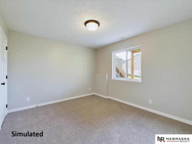 spare room with carpet and a textured ceiling