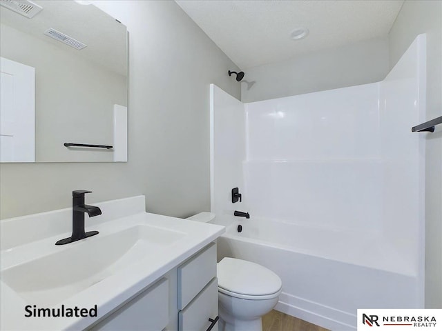 full bathroom featuring bathtub / shower combination, a textured ceiling, vanity, hardwood / wood-style flooring, and toilet