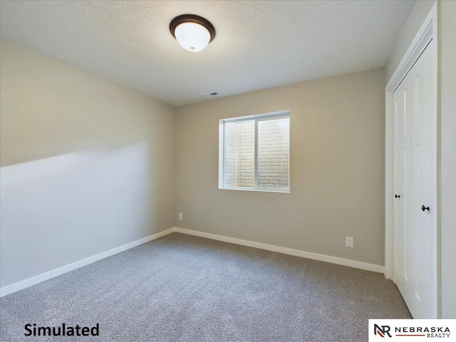 unfurnished bedroom with carpet flooring, a textured ceiling, and a closet