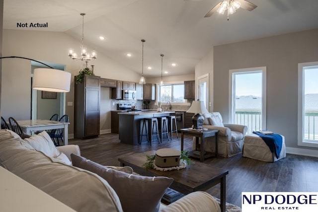 living room with dark hardwood / wood-style flooring, ceiling fan with notable chandelier, and vaulted ceiling