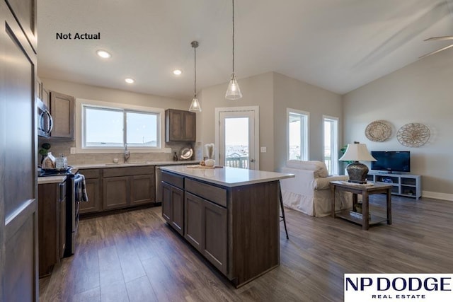 kitchen featuring a wealth of natural light, sink, a kitchen island, and decorative light fixtures