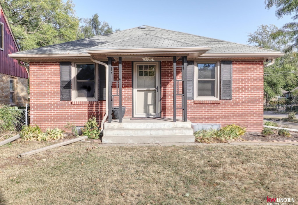 bungalow-style home with a front lawn