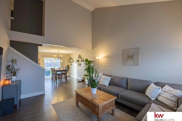 living room featuring a high ceiling, dark hardwood / wood-style flooring, and a notable chandelier