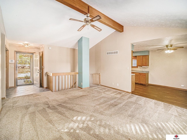 unfurnished living room featuring vaulted ceiling with beams, light wood-type flooring, and ceiling fan