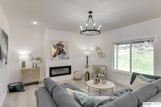 living room with light wood-type flooring and a chandelier