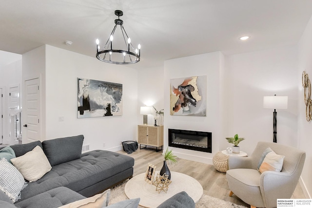 living room with a chandelier and light wood-type flooring