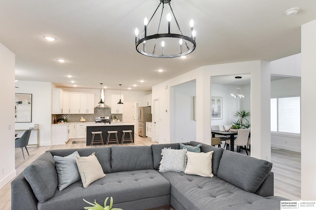 living room featuring a chandelier and light hardwood / wood-style floors