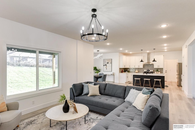 living room featuring a notable chandelier and light wood-type flooring