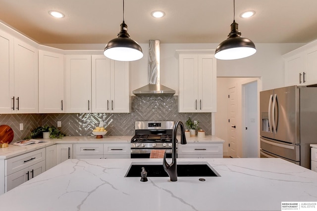 kitchen with white cabinetry, hanging light fixtures, light stone counters, decorative backsplash, and appliances with stainless steel finishes