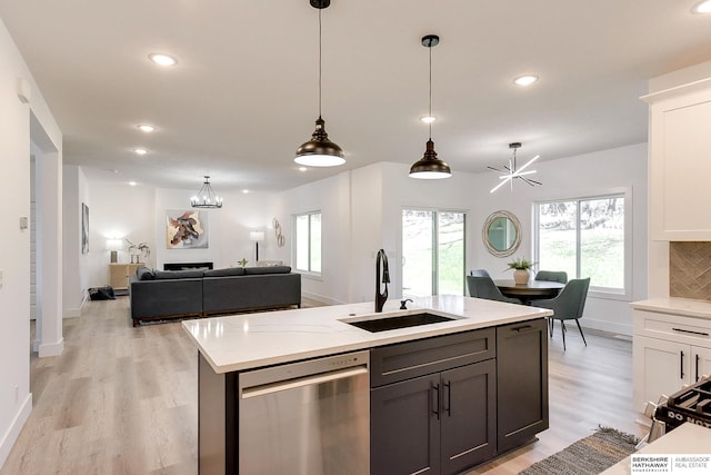 kitchen with dishwasher, sink, tasteful backsplash, decorative light fixtures, and white cabinetry