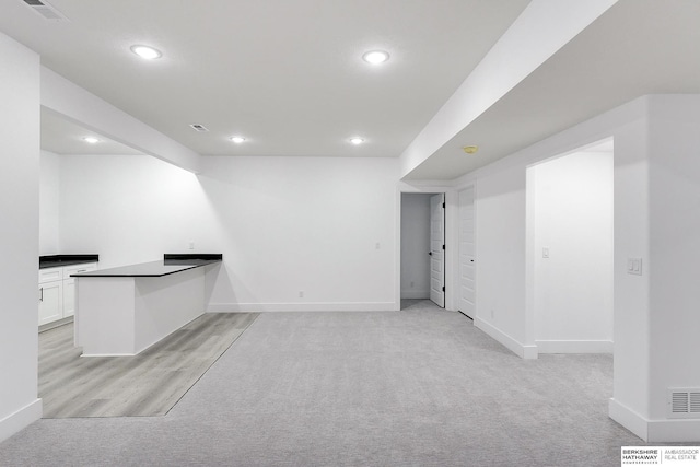 interior space featuring white cabinetry and light carpet