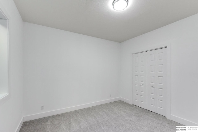 unfurnished bedroom featuring light colored carpet and a closet