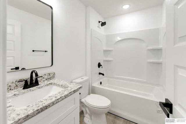 full bathroom featuring toilet, wood-type flooring, vanity, and bathing tub / shower combination