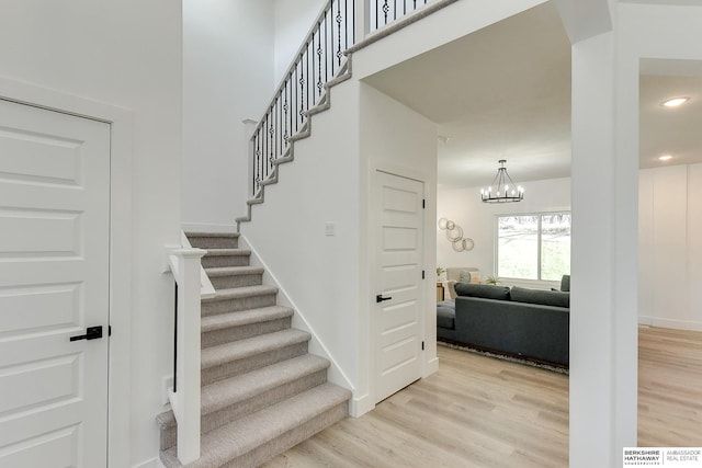 stairway featuring a chandelier and wood-type flooring