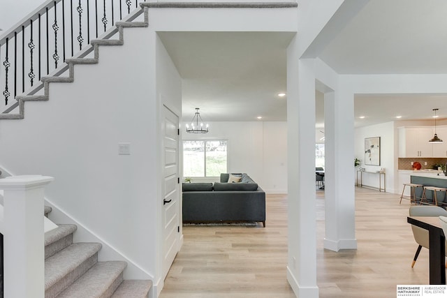 staircase featuring hardwood / wood-style floors and a notable chandelier