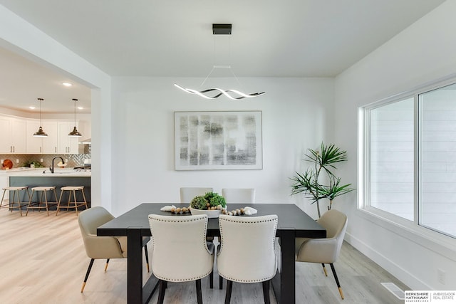 dining room with light hardwood / wood-style flooring and sink