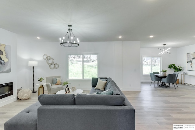 living room with a chandelier and light wood-type flooring