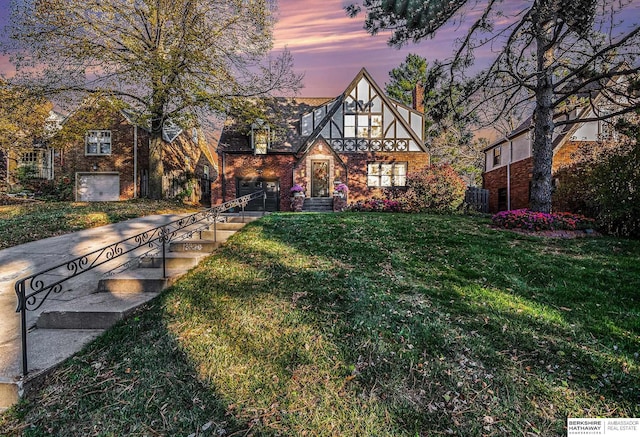 english style home with a lawn