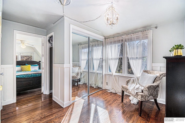 living area featuring ceiling fan with notable chandelier, dark wood-type flooring, and vaulted ceiling