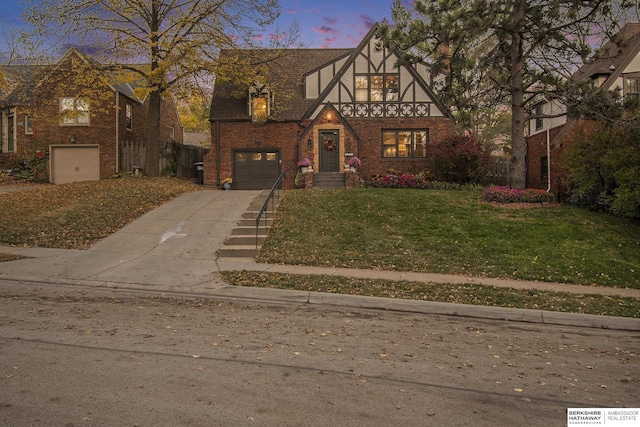 tudor-style house with a garage and a lawn