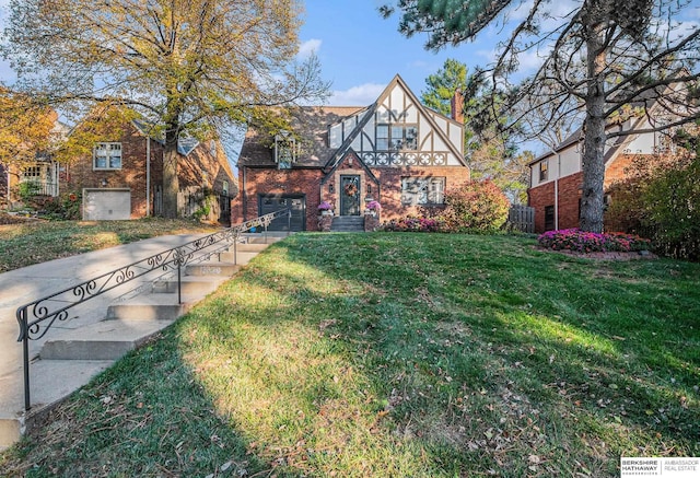 english style home with a garage and a front lawn