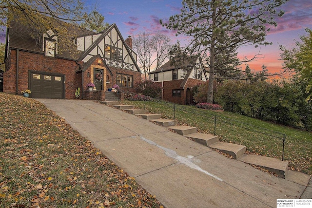 tudor house with a garage and a yard