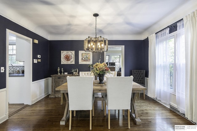 dining space with dark hardwood / wood-style floors, an inviting chandelier, and plenty of natural light