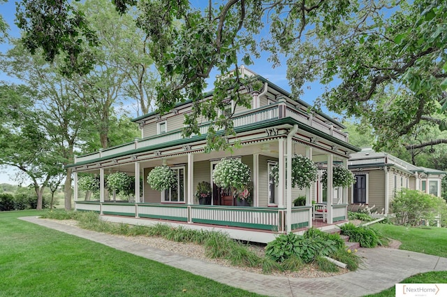 rear view of house with covered porch and a lawn