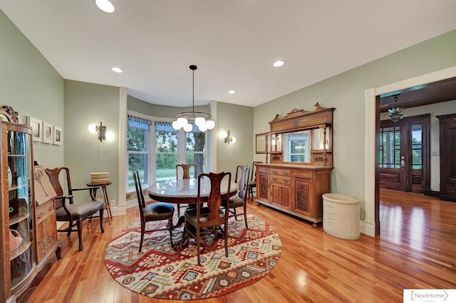 dining room featuring light wood-type flooring and a notable chandelier