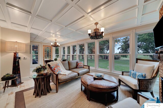 sunroom / solarium featuring beamed ceiling, coffered ceiling, and a notable chandelier