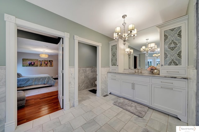 bathroom with hardwood / wood-style flooring, a notable chandelier, and vanity