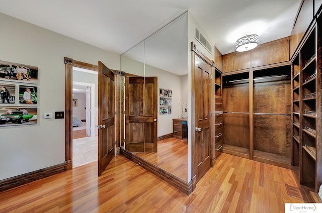 walk in closet with hardwood / wood-style floors and vaulted ceiling