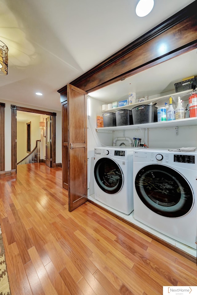 laundry room with separate washer and dryer and light hardwood / wood-style flooring