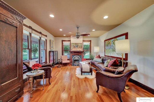 living room featuring ceiling fan, a healthy amount of sunlight, and light wood-type flooring