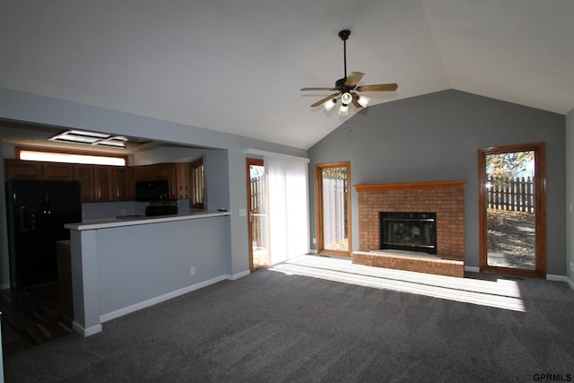 unfurnished living room with carpet, ceiling fan, a brick fireplace, and vaulted ceiling