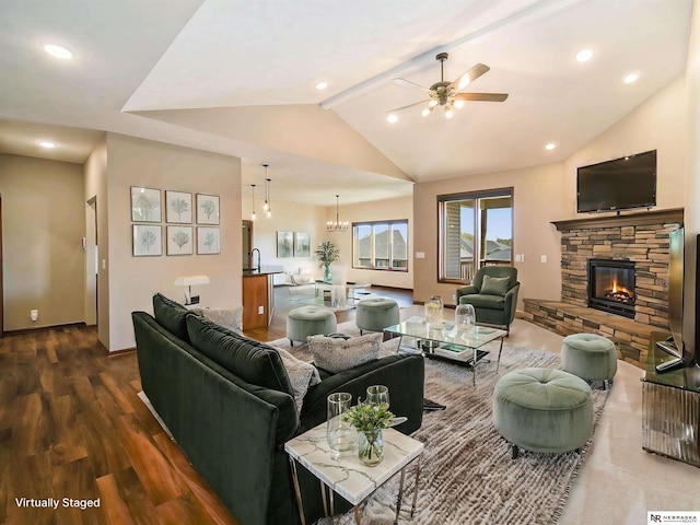 living room with ceiling fan with notable chandelier, dark wood-type flooring, beam ceiling, high vaulted ceiling, and a fireplace