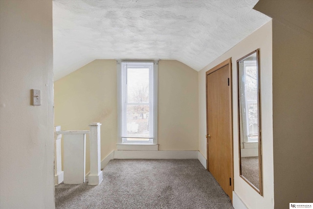 bonus room with a textured ceiling, lofted ceiling, and carpet floors