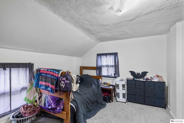 carpeted bedroom featuring a textured ceiling and lofted ceiling