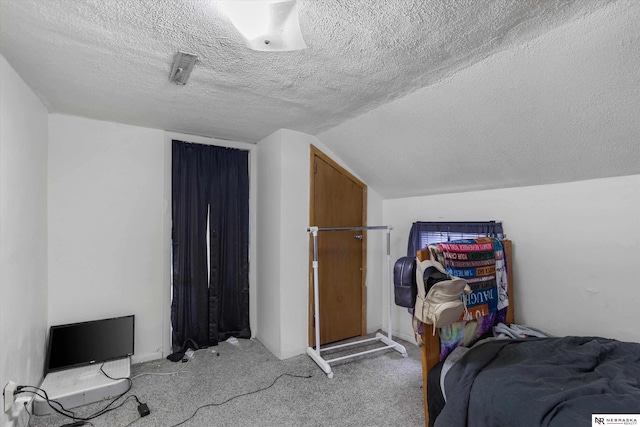 carpeted bedroom featuring lofted ceiling and a textured ceiling