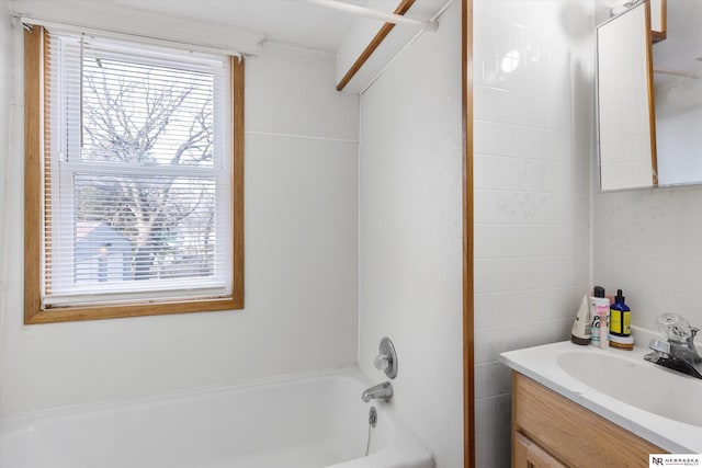 bathroom with vanity, tile walls, and tub / shower combination