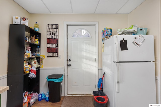 kitchen featuring hardwood / wood-style flooring, a drop ceiling, and white refrigerator