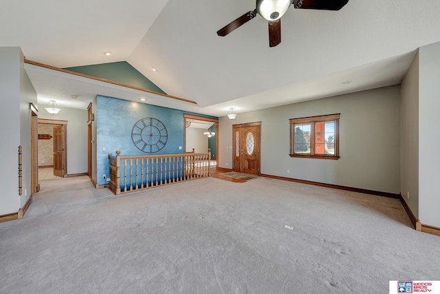 unfurnished living room featuring ceiling fan, light colored carpet, and vaulted ceiling