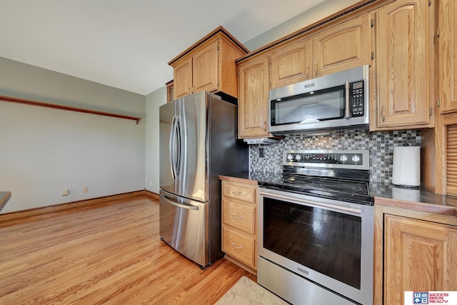 kitchen with light hardwood / wood-style flooring, appliances with stainless steel finishes, and tasteful backsplash