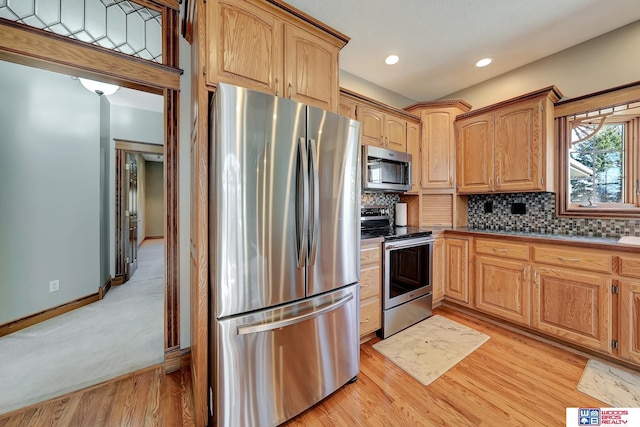 kitchen with backsplash, stainless steel appliances, and light hardwood / wood-style floors