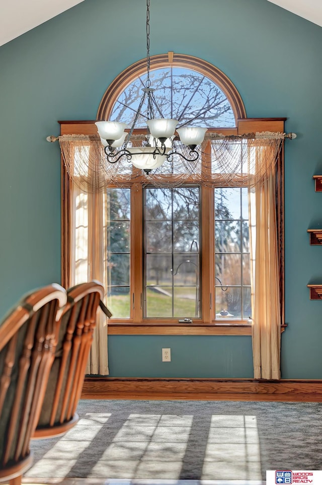 unfurnished dining area featuring a notable chandelier, plenty of natural light, and lofted ceiling