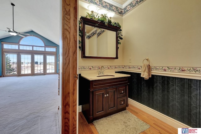 bathroom with hardwood / wood-style flooring, ceiling fan, high vaulted ceiling, and vanity