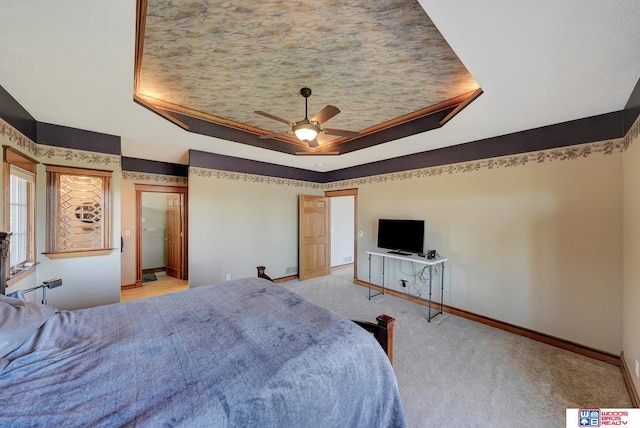 bedroom featuring a tray ceiling, ceiling fan, and light colored carpet