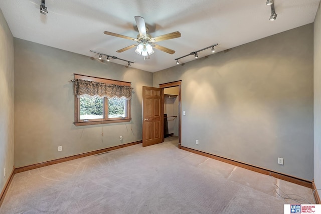 unfurnished bedroom with light carpet, ceiling fan, and track lighting